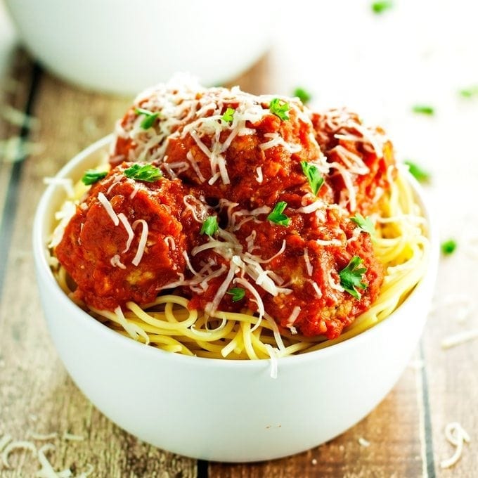 baked turkey meatballs served over spaghetti and topped with homemade tomato sauce and parmesan cheese