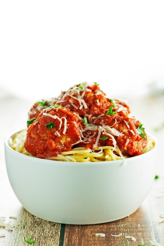 baked turkey meatballs piled high over spaghetti in a bowl