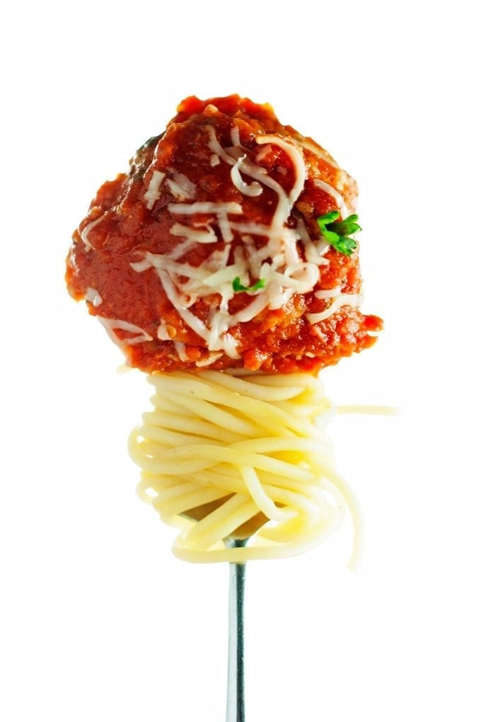 baked turkey meatball displayed on a fork with spaghetti