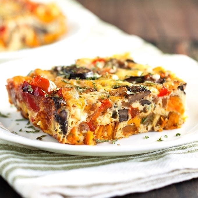 Egg bake piece bursting with the vibrant colors of sweet potatoes, peppers, mushrooms, and onions