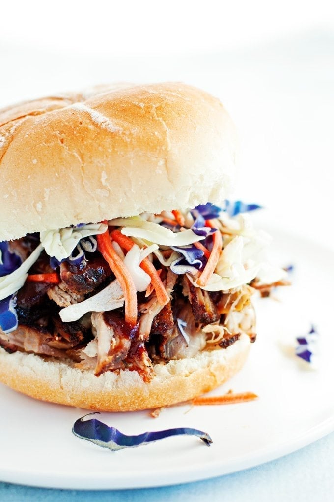 close up of a pulled pork sandwich dripping with bbq sauce