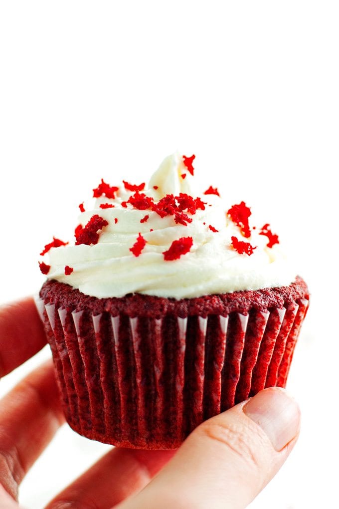 red velvet cupcake being held, ready to eat.