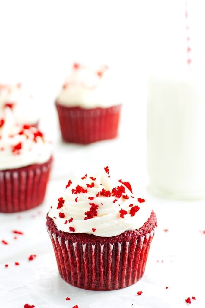 red velvet cupcakes topped with cream cheese frosting served with a ice cold milk