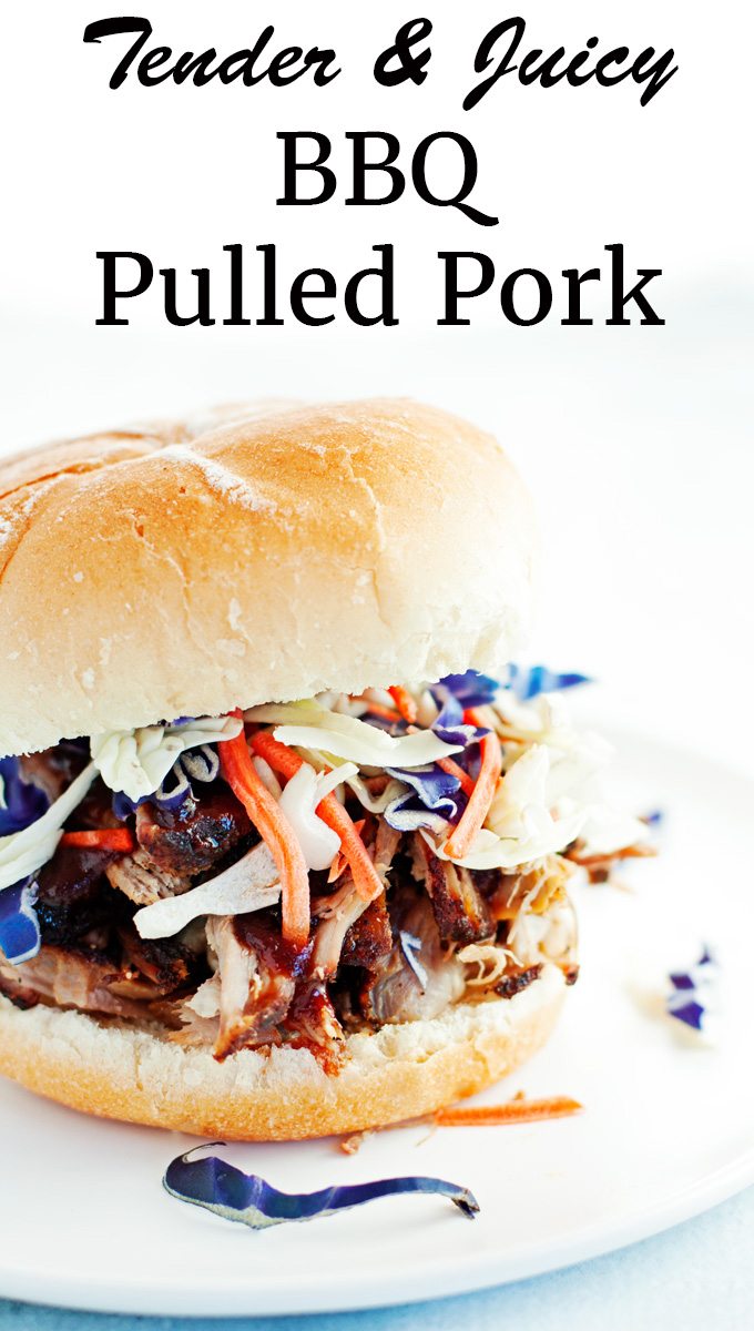 close up of a tender juicy bbq pulled pork sandwich on a toasted bun topped with colorful purple cabbage and shredded carrots