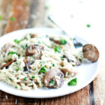 plate and fork full of creamy chicken and mushroom risotto